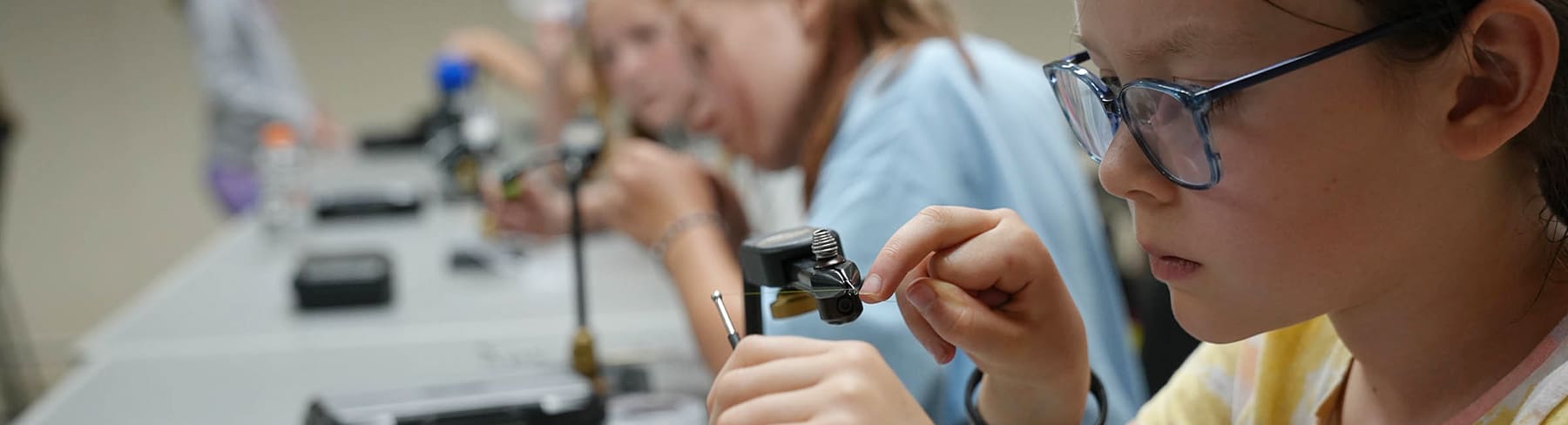 Summer camp kids in fly tying class
